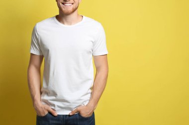 Sarı arka planda boş t-shirt giyen genç adam, closeup. Tasarım için mockup