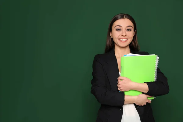 Retrato de un joven profesor con cuadernos sobre fondo verde. Espacio para texto — Foto de Stock