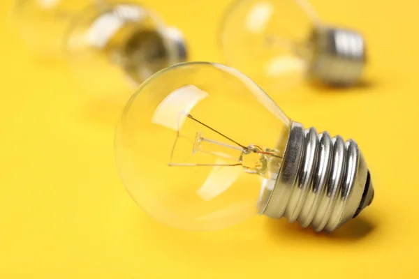 黄色の背景に新しい白熱ランプ電球 — ストック写真