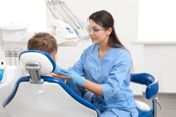 Klinikte küçük çocuk ile çalışan profesyonel dişçi — Stok fotoğraf