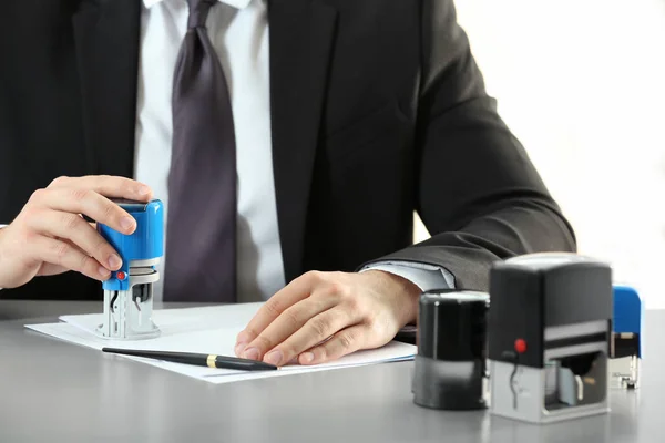 Male notary stamping document at table, closeup — Stock Photo, Image