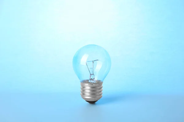 水色の背景に新しい近代的なランプ電球 — ストック写真