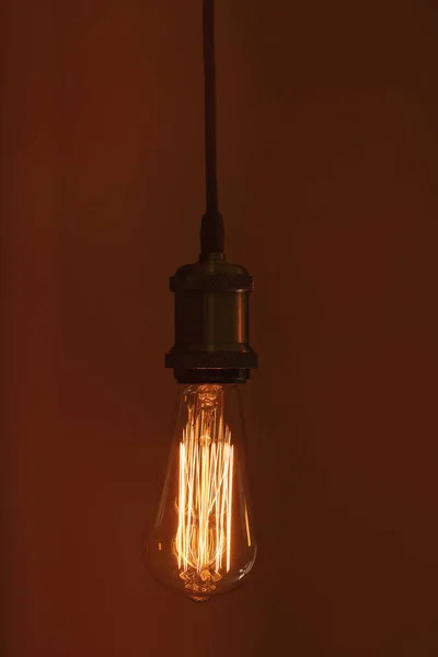 Висячая современная лампочка на коричневом фоне — стоковое фото