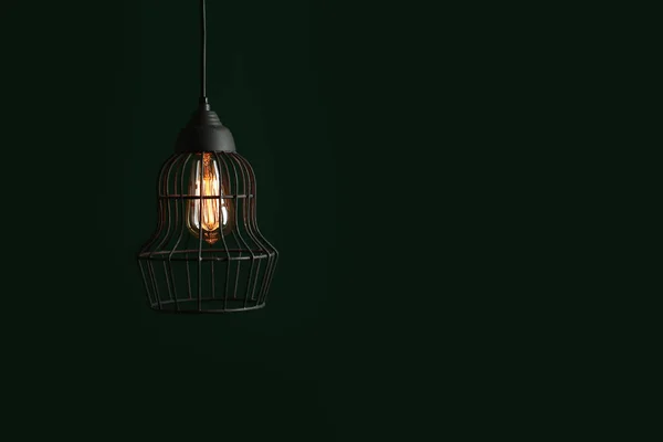 Hangende lamp lamp in kroonluchter tegen groene achtergrond, ruimte voor tekst — Stockfoto