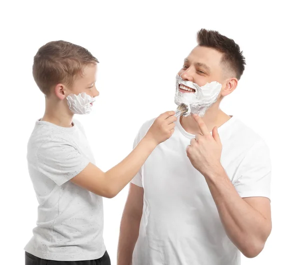Syn stosując piankę do golenia na twarzy taty, białe tło — Zdjęcie stockowe