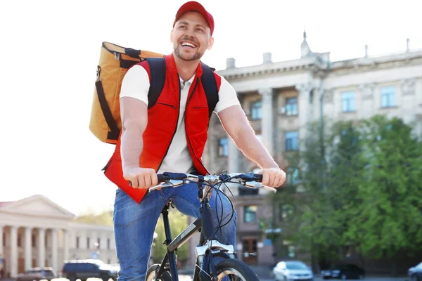 Mužský kurýr na kole dodávající jídlo ve městě — Stock fotografie