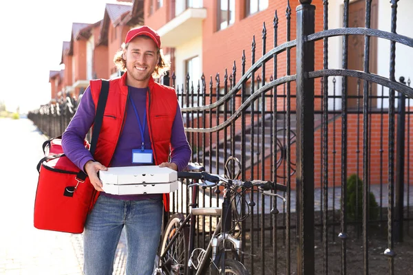 Courrier masculin livrant de la nourriture en ville le jour ensoleillé — Photo