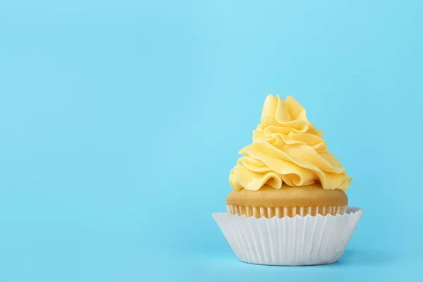 Gâteau savoureux avec crème sur fond bleu clair, espace pour le texte — Photo