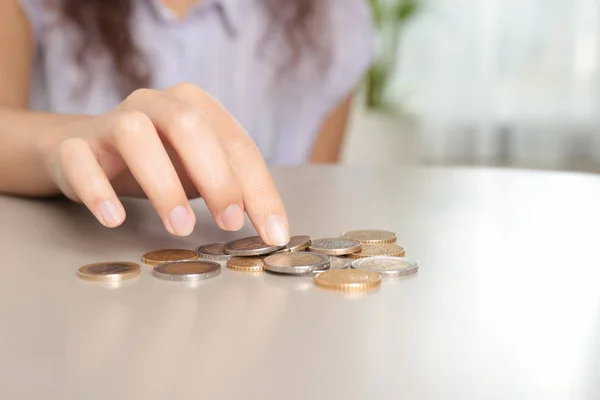 Fiatal nő számolás érmék asztalra, closeup. Szóköz a szöveghez — Stock Fotó