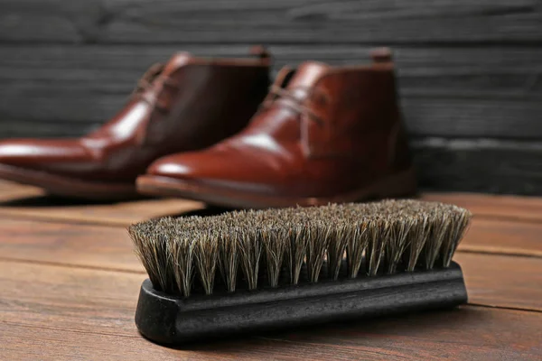 Brosse à chaussures et chaussures en cuir sur surface en bois — Photo