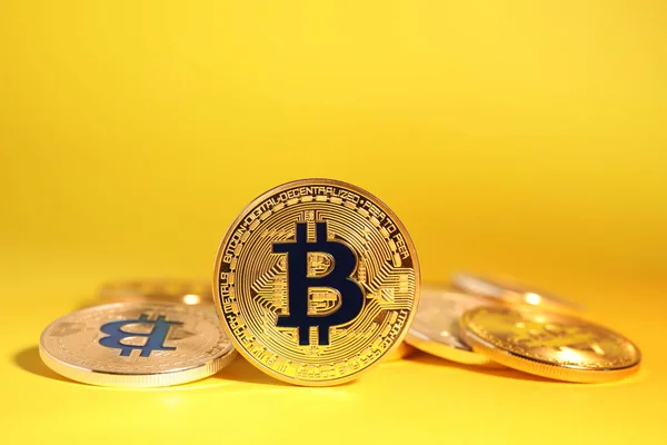 Bitcoins brilhantes no fundo amarelo. Moeda digital — Fotografia de Stock