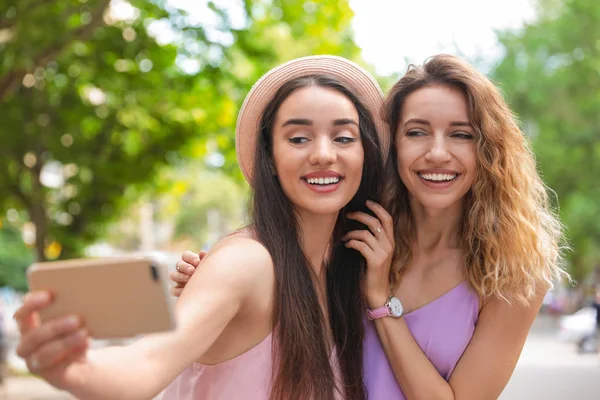 Jovens mulheres bonitas tomando selfie ao ar livre no dia ensolarado — Fotografia de Stock