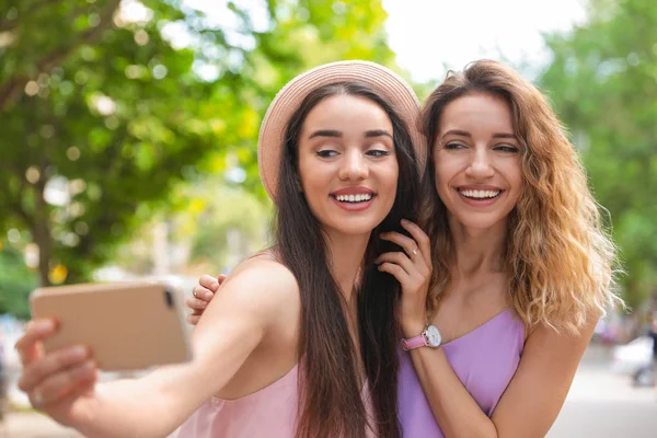 Hermosas mujeres jóvenes tomando selfie al aire libre en el día soleado — Foto de Stock