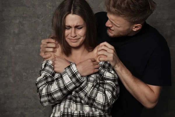 Man abusing young woman on grey background. Stop sexual assault — Stock Photo, Image