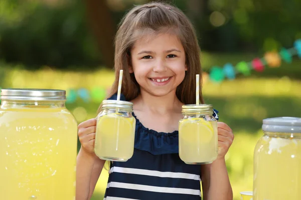 Söt liten flicka med naturlig lemonad i parken. Sommar uppfriskande drink — Stockfoto