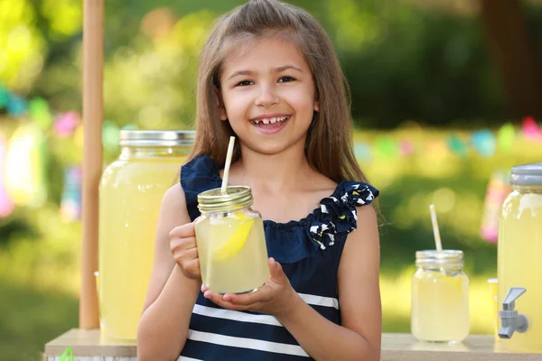 可爱的小女孩与天然柠檬水在公园。夏季清凉饮料 — 图库照片