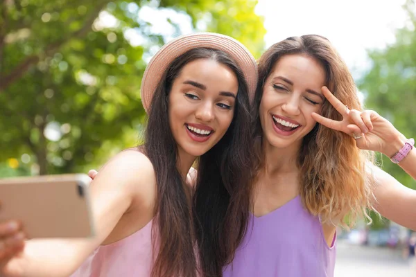 Hermosas mujeres jóvenes tomando selfie al aire libre en el día soleado — Foto de Stock