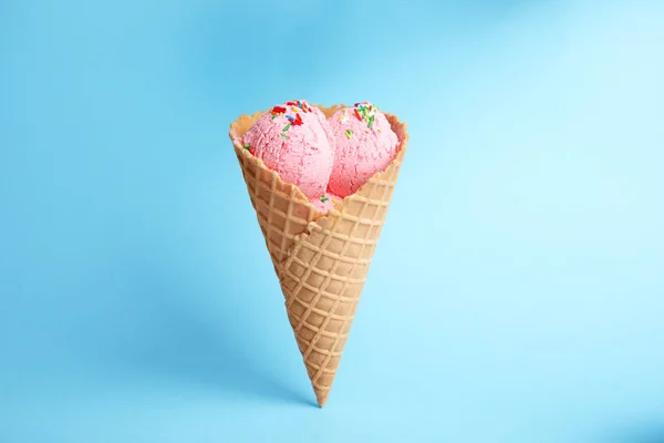 Delicioso sorvete em cone de bolacha no fundo azul — Fotografia de Stock