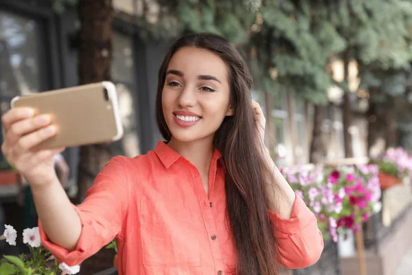 Krásná mladá žena brát selfie venku na slunný den — Stock fotografie