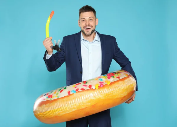 Lustige Geschäftsmann mit hellen aufblasbaren Ring auf blauem Hintergrund — Stockfoto