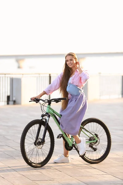 Mujer joven montando bicicleta en la ciudad en un día soleado —  Fotos de Stock