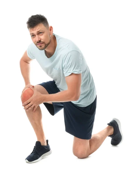 Full length portrait of sportsman having knee problems on white background