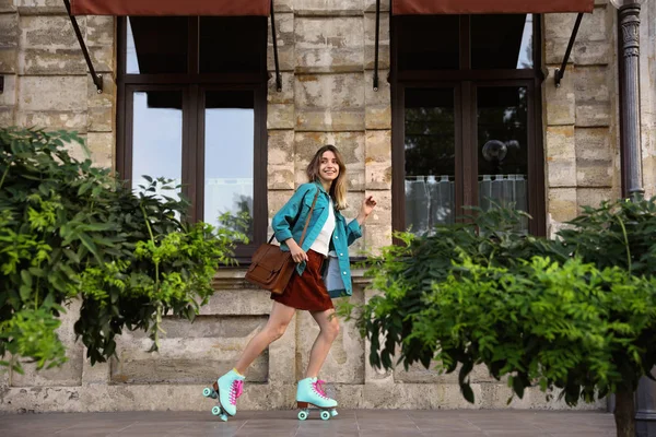 Feliz mujer joven con estilo con patines de ruedas vintage y bolso en la calle —  Fotos de Stock