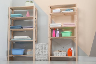 Şık oda içi temiz havlu ve deterjanlar ile ahşap raf üniteleri