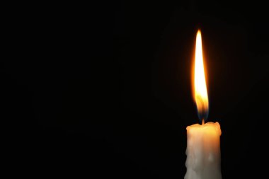 Karanlık arka planda yanan mum, metin için alan. Keder sembolü