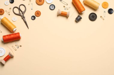 Açık sarı arka planda makas ve diğer dikiş aksesuarları ile düz yatıyordu kompozisyon, metin için alan