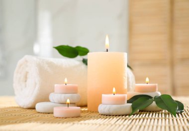 Bambu mat Spa taşlar, havlu ve yanan mumlar bileşimi