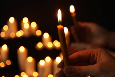 Karanlıkta bulanık arka plan, çekim karşı karanlığa yanan mum tutan kadın. Metin alanı
