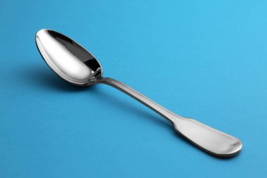 Mavi arka planda temiz boş çay kaşığı
