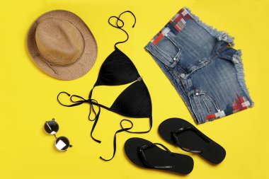 Sarı arka planda şık plaj aksesuarları ile düz yatıyordu kompozisyon