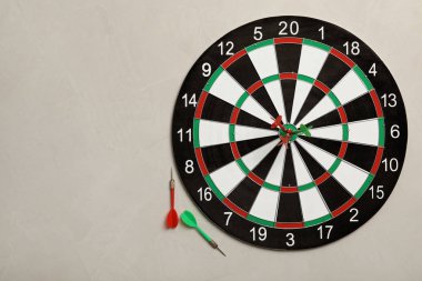 Hafif taş arka planda renk okları ile dart tahtası, üst görünüm. Metin alanı