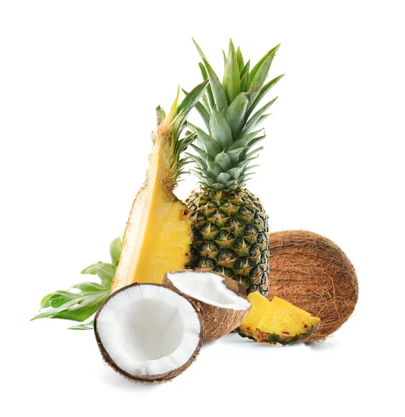Вкусные кокосы и спелые сочные ананасы на белом фоне — стоковое фото
