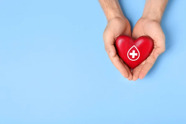 Man som innehar rött hjärta på blå bakgrund, uppifrån med utrymme för text. Donation begrepp — Stockfoto