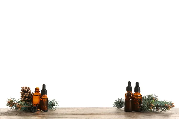 Composição com garrafas de óleo essencial de conífera na mesa contra fundo branco. Espaço para texto — Fotografia de Stock