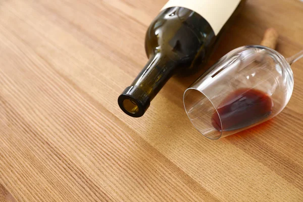 Umgekipptes Glas und eine Flasche Wein auf hölzernem Hintergrund. Raum für Text — Stockfoto