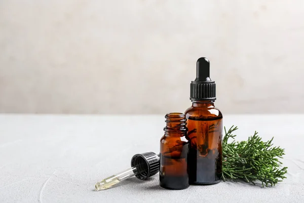 Composition with bottles of conifer essential oil on light table. Space for text — Stock Photo, Image