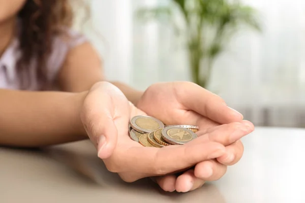 テーブルでコインの一握りを持つ若い女性, クローズアップ — ストック写真
