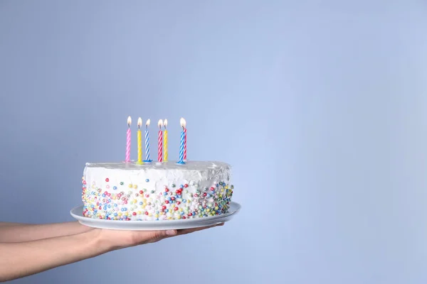 Woman holding birthday cake with burning candles on light blue background, closeup. Space for text — Stock Photo, Image