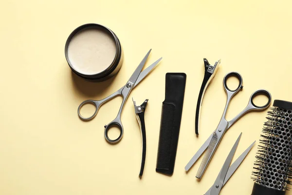 Ножиці та інші аксесуари для перукарів на світло-жовтому тлі, плоский ліжко — стокове фото