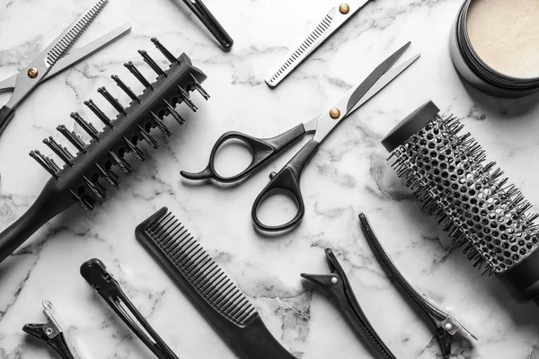 Composición plana con tijeras y otros accesorios de peluquería sobre fondo de mármol blanco —  Fotos de Stock