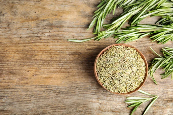 Schale mit getrocknetem Rosmarin und frischen Blättern auf Holzuntergrund, flach gelegt. Raum für Text — Stockfoto