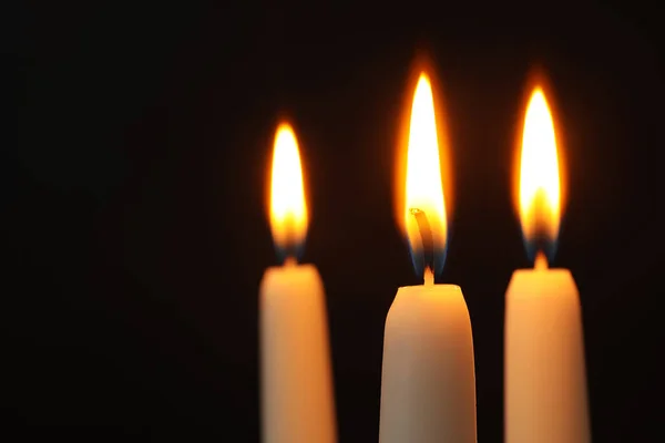 Velas encendidas sobre fondo oscuro, espacio para texto. Símbolo del dolor —  Fotos de Stock