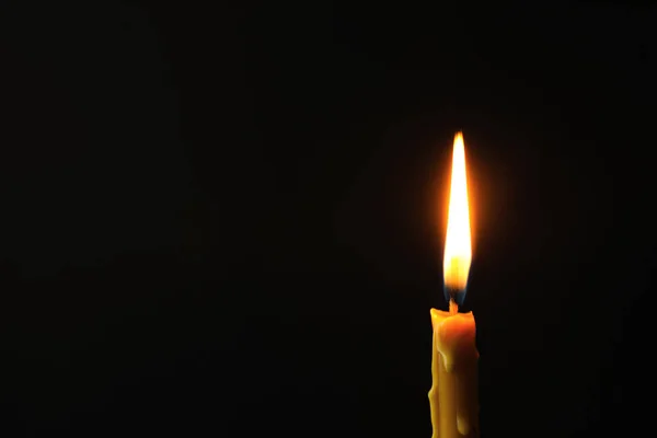 Зажигание свечи на тёмном фоне, место для текста. Символ скорби — стоковое фото