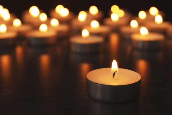Hořící svíčky na dřevěném stole, prostor pro text. Symbol smutku — Stock fotografie