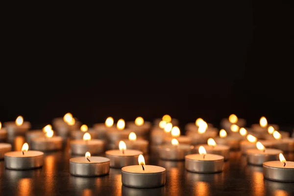 Molte candele accese sul tavolo sullo sfondo scuro. Simbolo del dolore — Foto Stock