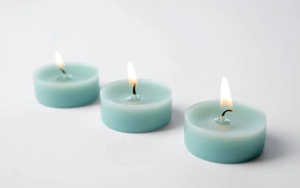 Velas decorativas de cera azul clara isoladas em branco — Fotografia de Stock